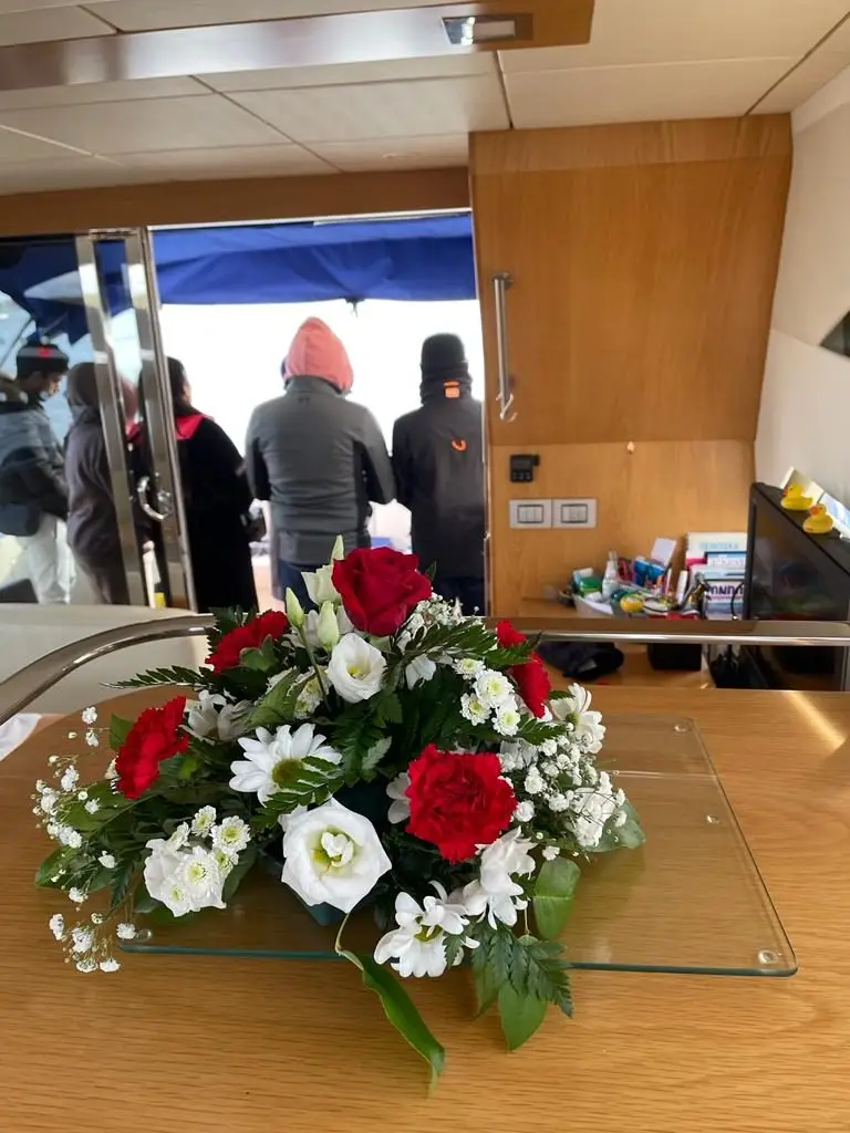 A floral tribute on board, with family gathered at the stern