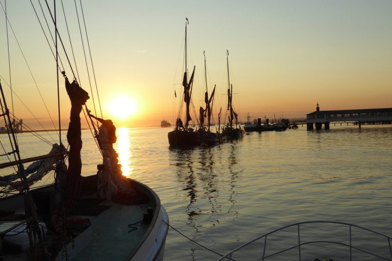 Sunset over the water, with Thames sailing barges at their moorings